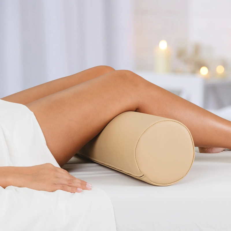 Full round bolster massage pillow shown in use under the knees by Earthlite